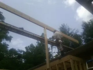 Carpenter setting a ridge beam over a new addition frame — Ice Dam Removal by Roofing Brothers in Lily