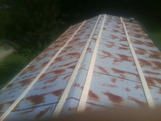Rusted metal roof panels with new wood purlins before replacement — Storm Damage Roof Repair in Lily by Roofing Brothers