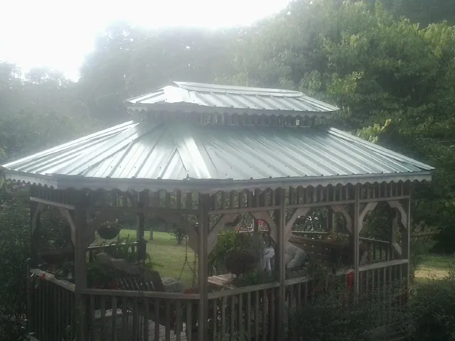 Two tier green metal roof on a garden gazebo in Lily