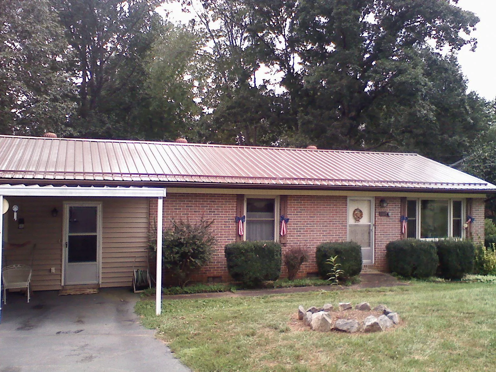 Bronze metal roof and carport on a brick ranch home — Roof Repair work by our crew in Lily